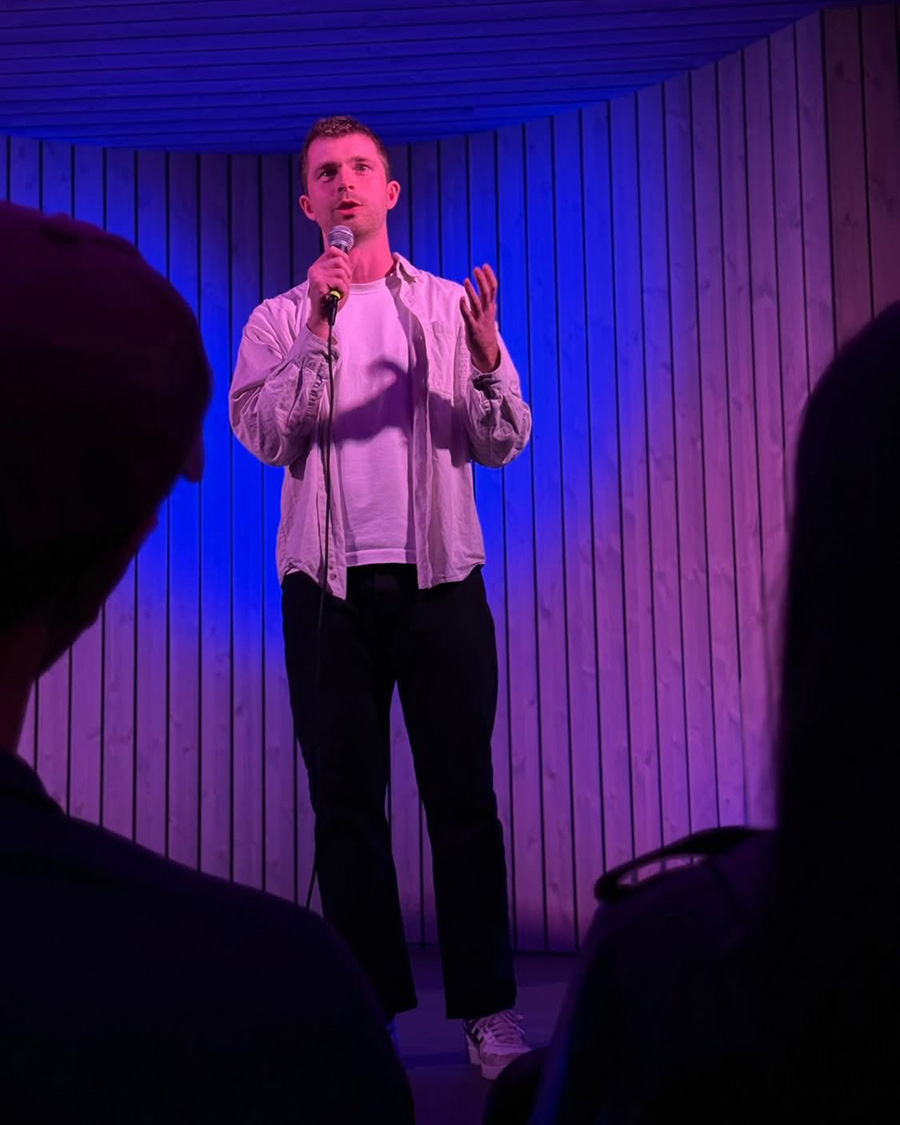 Standup-komiker på en lilla-opplyst scene