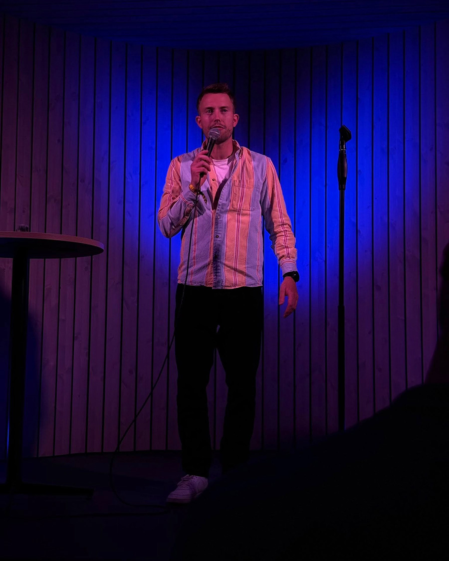 Standup-komiker som snakker i mikrofonen på scenen